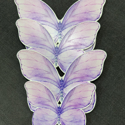 Purple butterfly cutout decorations arranged in a stack on a dark surface from WPE Production backdrops