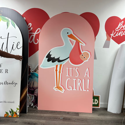 Pink custom foam backdrop printing with stork carrying a baby and text its a girl for baby shower