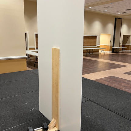 Durable support leg for display boards made of wood holding a white board upright in event space