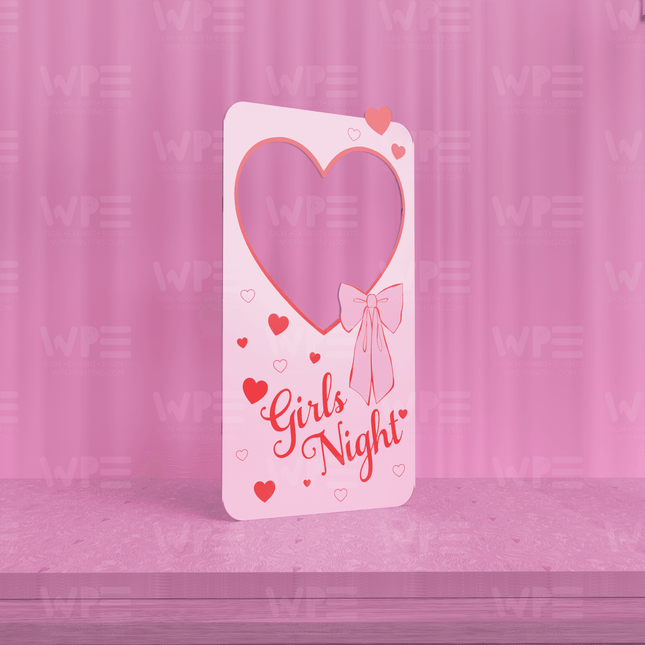 Girls night photo backdrop in pink with heart designs and a cute bow for themed parties
