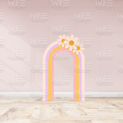 Groovy birthday backdrop decorations featuring pastel rainbow arch with smiling flower accents against pink wall