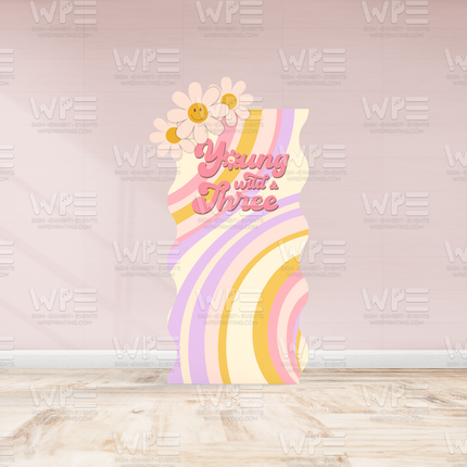 Colorful groovy birthday backdrop decorations with retro stripes and flower accents saying Young with a Three