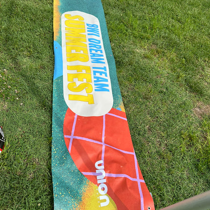 Brightly colored custom printed vinyl banners for outdoor events by WPEProduction displayed on grass