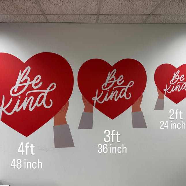 Three red heart-shaped personalized vinyl sticker printing designs with Be Kind text in different sizes held by hands