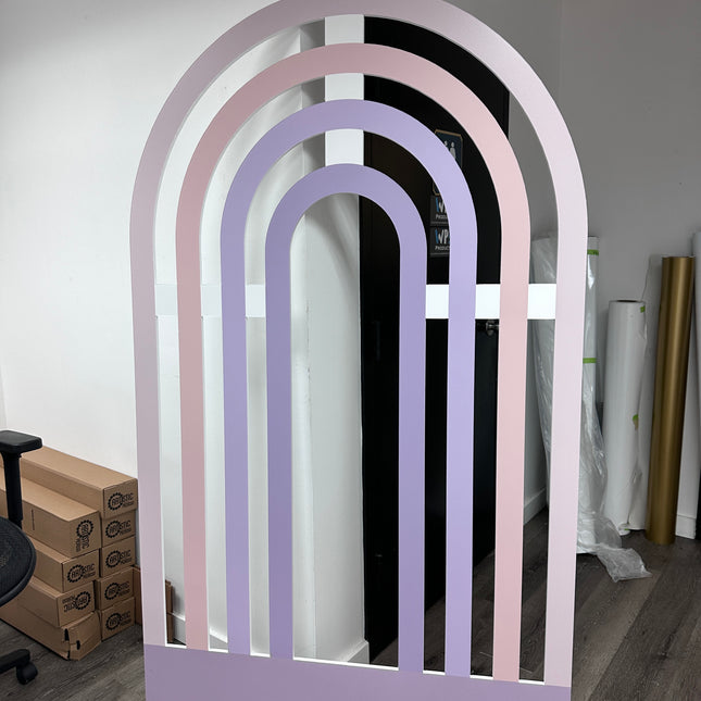 Large pastel rainbow foam board backdrop with soft pink and purple arches for event decoration