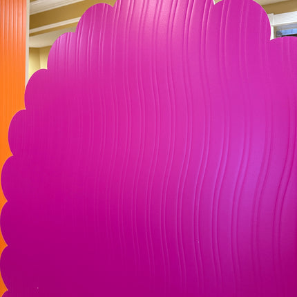 Bright pink decorative panel next to vibrant orange and pink displays for event decor by WPE Production