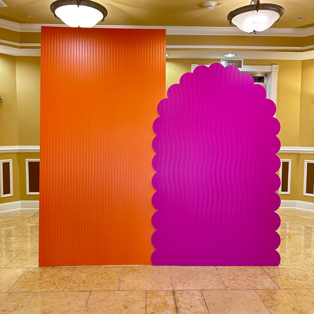 Vibrant orange and pink displays with textured surfaces showcased in an indoor event space
