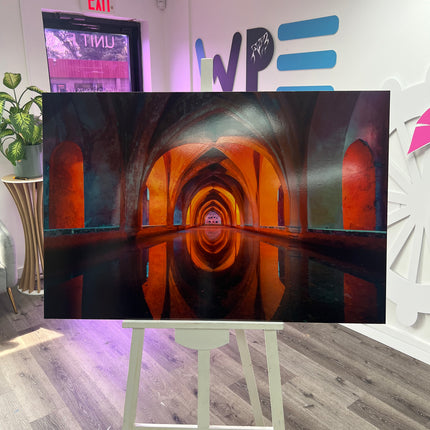 Custom photo prints on foam board displaying an illuminated arched hallway with reflective water on a white easel