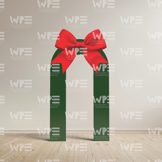 Holiday ribbon arch decoration featuring green ribbons and a large red bow for festive events